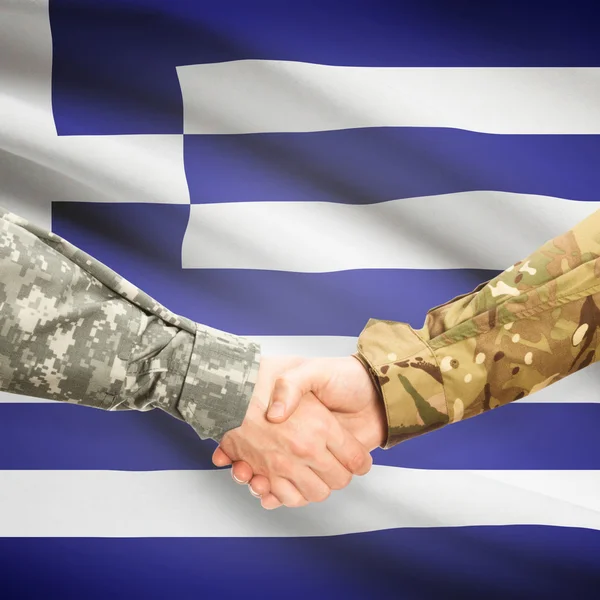Hommes en uniforme se serrant la main avec le drapeau sur fond - Grèce — Photo