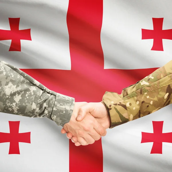 Men in uniform shaking hands with flag on background - Georgia — Stock Photo, Image