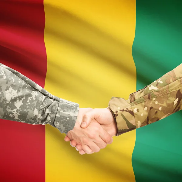 Uomini in uniforme che agitano le mani con la bandierina su priorità bassa - Guinea — Foto Stock