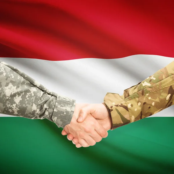 Männer in Uniform Händeschütteln mit Flagge auf Hintergrund - Ungarn — Stockfoto