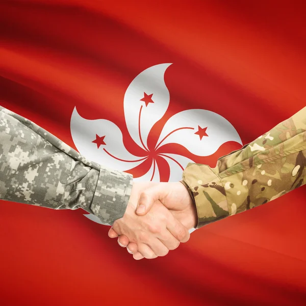 Men in uniform shaking hands with flag on background - Hong Kong — Stock Photo, Image