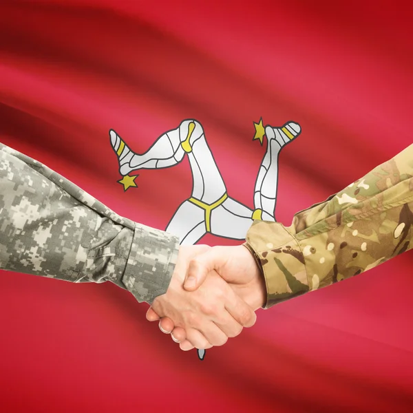 Men in uniform shaking hands with flag on background - Isle of M — Stock Photo, Image
