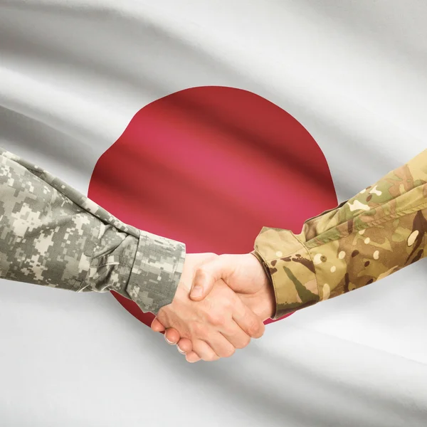 Homens de uniforme, cumprimentando-se com a bandeira no fundo - Japão — Fotografia de Stock