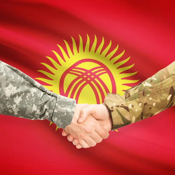 Mannen in uniform schudden handen met vlag op achtergrond - Kyrgyzsta — Stockfoto