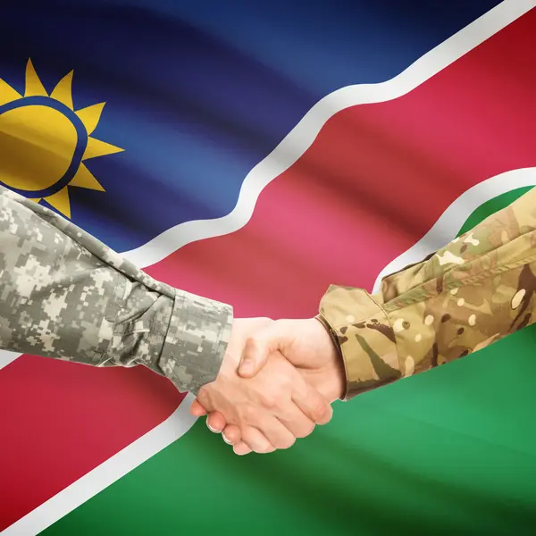 Люди в форме, пожимая руки с флагом на фоне - Намибия — стоковое фото