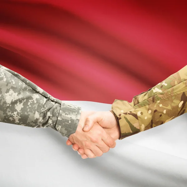 Men in uniform shaking hands with flag on background - Monaco — Stock Photo, Image