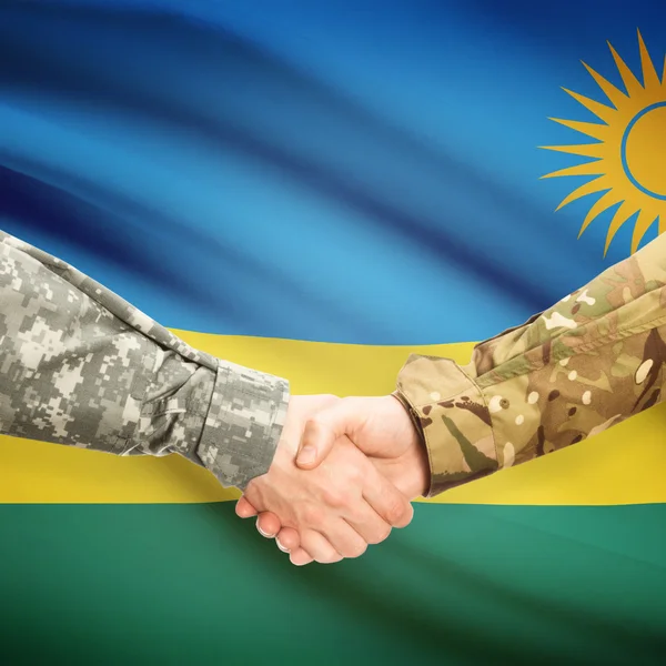Men in uniform shaking hands with flag on background - Rwanda — Stock Photo, Image