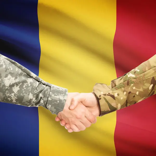 Men in uniform shaking hands with flag on background - Romania — Stock Photo, Image