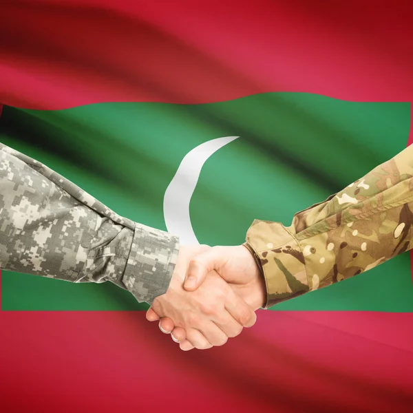 Люди в форме, пожимая руки с флагом на фоне - Мальдивы — стоковое фото