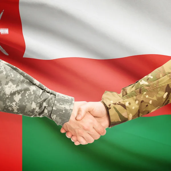 Männer in Uniform Händeschütteln mit Flagge auf Hintergrund - Oman — Stockfoto