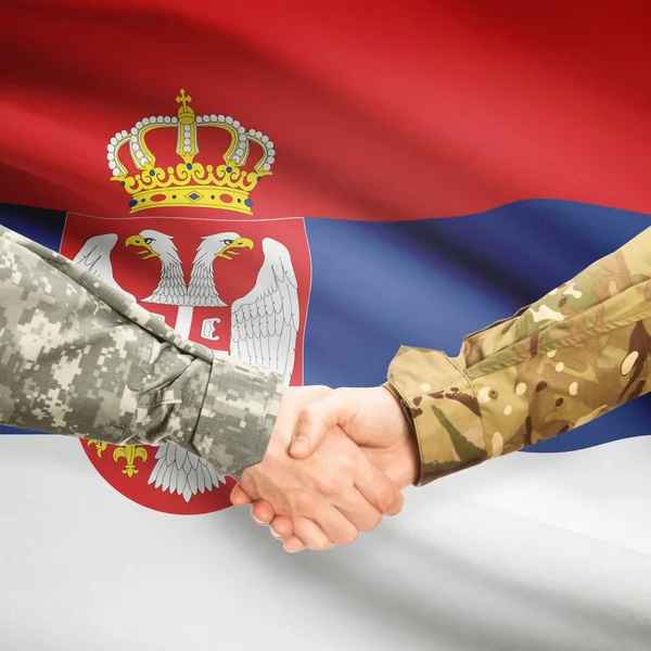 Men in uniform shaking hands with flag on background - Serbia — Stock Photo, Image