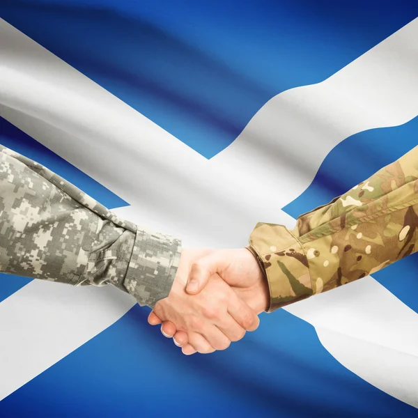 Men in uniform shaking hands with flag on background - Scotland — Stock Photo, Image