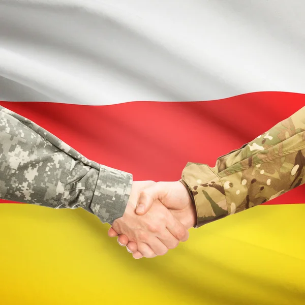 Mannen in uniform schudden handen met vlag op achtergrond - Zuid-Oss — Stockfoto