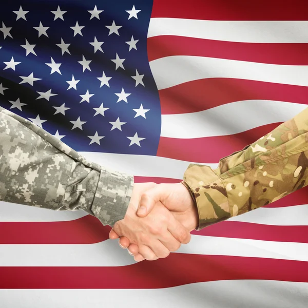 Men in uniform shaking hands with flag on background - United St — Stock Photo, Image