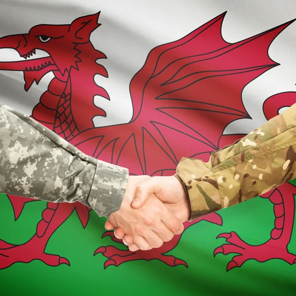 Men in uniform shaking hands with flag on background - Wales — Stock Photo, Image