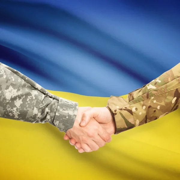 Hombres en uniforme de estrecharme la mano con la bandera en el fondo - Ucrania —  Fotos de Stock