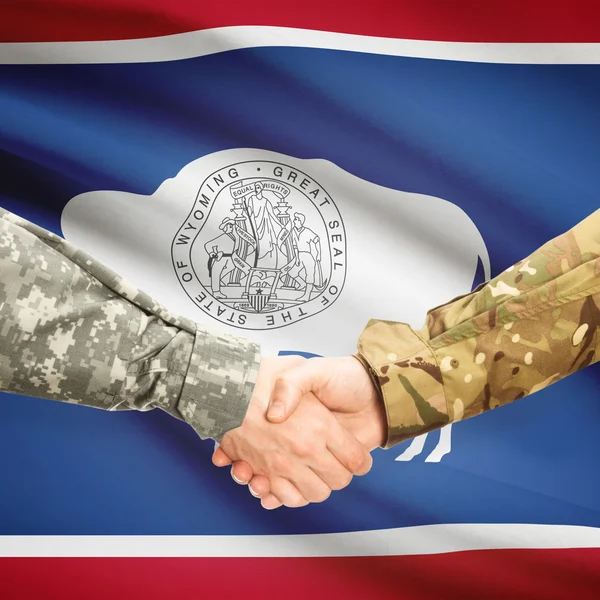Vojenské handshake a nás státní vlajky - Wyoming — Stock fotografie