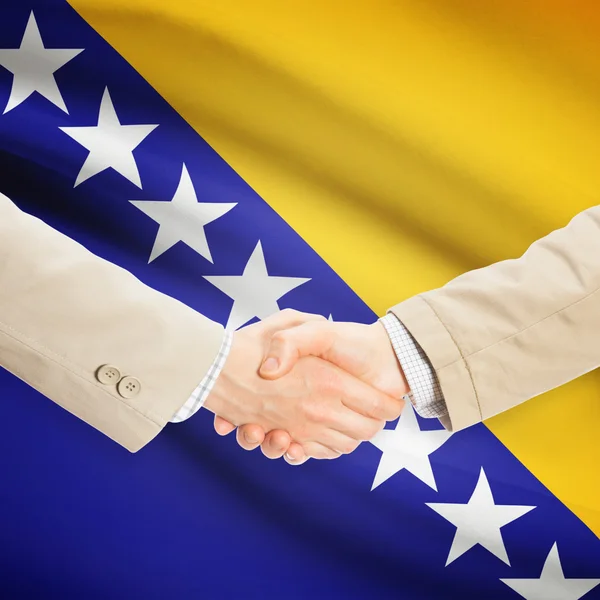 Apretón de manos de empresarios con bandera sobre fondo - Bosnia y Herze — Foto de Stock