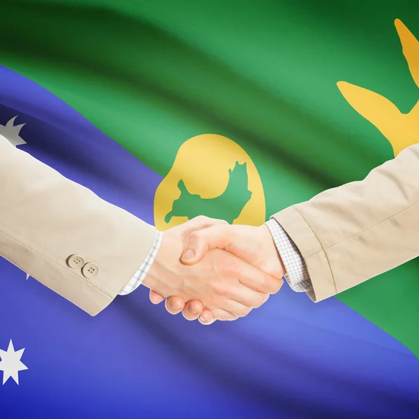 Üzletemberek kézfogás zászló a háttérben - Karácsony-sziget — Stock Fotó