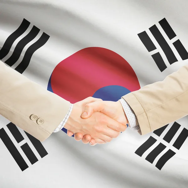 Apretón de manos de empresarios con bandera sobre fondo - Corea del sur —  Fotos de Stock