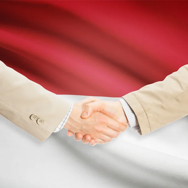 Бізнесмени рукостискання з прапором на фоні - Індонезія — стокове фото