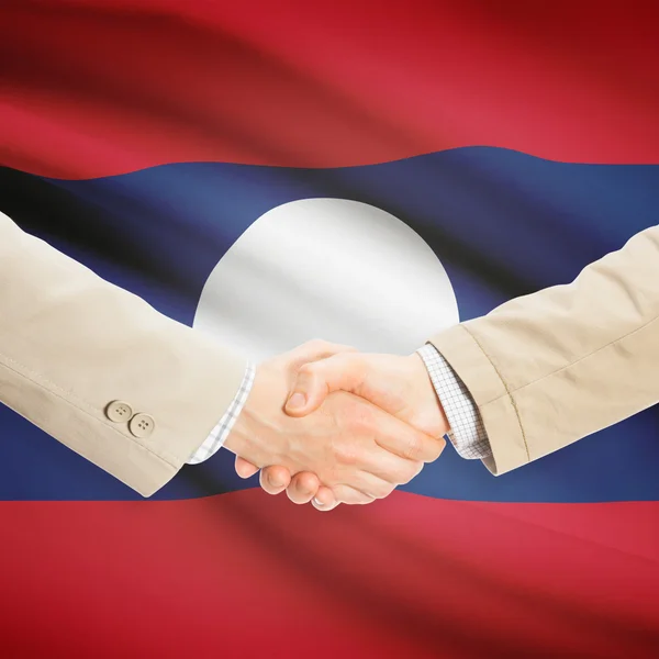 Unternehmer-Handshakes mit Flagge auf Hintergrund - Laos — Stockfoto