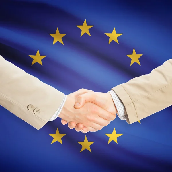 Aperto de mão de empresários com bandeira no fundo - UE - ONU Europeu — Fotografia de Stock