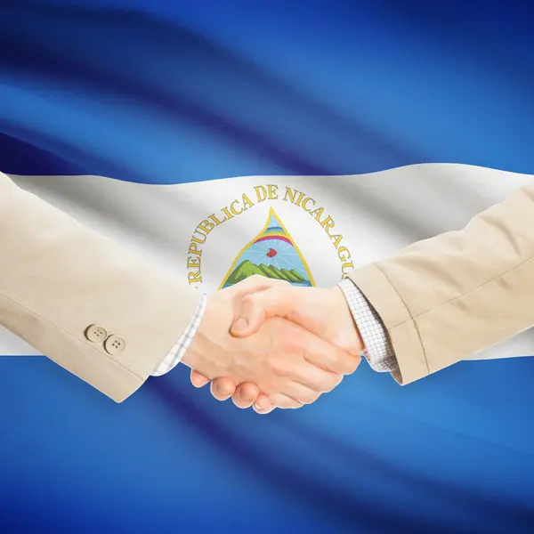 Poignée d'hommes d'affaires avec le drapeau sur fond - Nicaragua — Photo