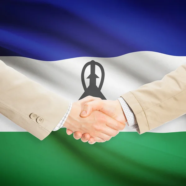 Предприниматели рукопожатие с флагом на фоне - Лесото — стоковое фото