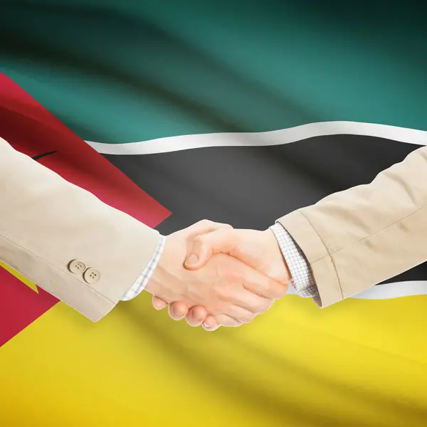 Предприниматели рукопожатие с флагом на фоне - Мозамбик — стоковое фото