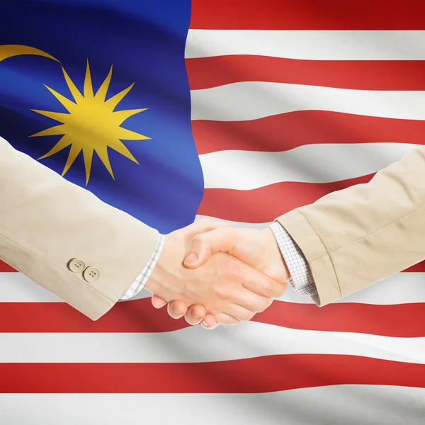 Businessmen handshake with flag on background - Malaysia — Stock Photo, Image