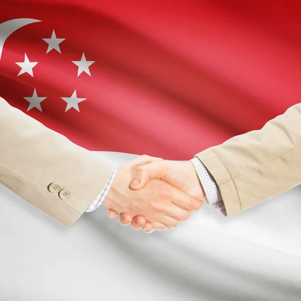 Affärsmän handslag med flagga på bakgrund - Singapore — Stockfoto