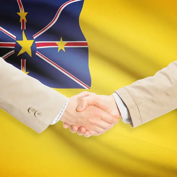 Businessmen handshake with flag on background - Niue — Stock Photo, Image