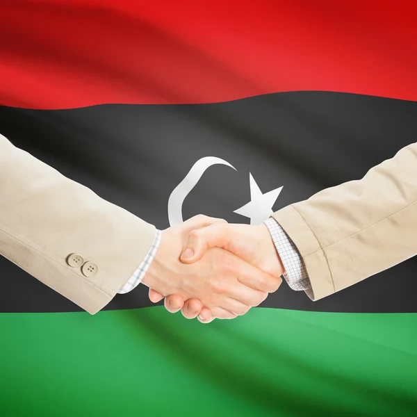 Businessmen handshake with flag on background - Libya — Stock Photo, Image