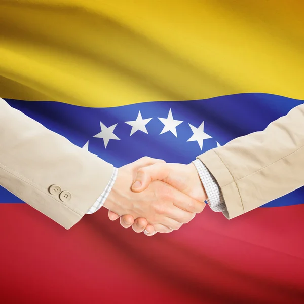 Unternehmer-Handshakes mit Flagge auf Hintergrund - Venezuela — Stockfoto