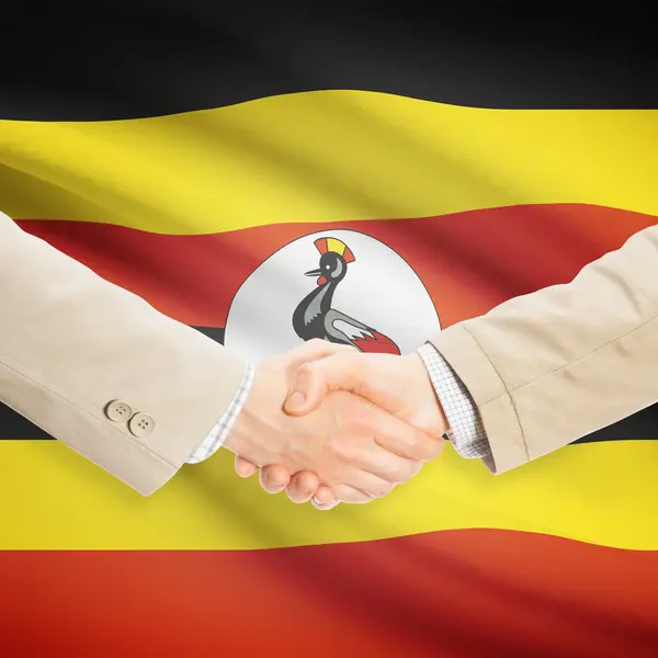 Unternehmer-Handshakes mit Flagge auf Hintergrund - Uganda — Stockfoto