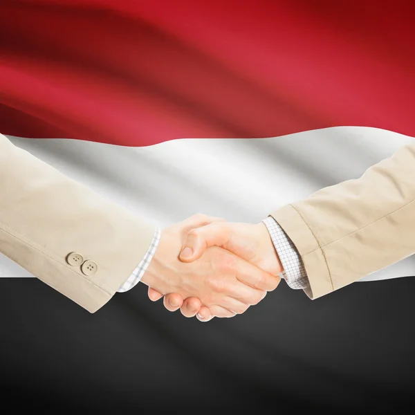 Предприниматели рукопожатие с флагом на фоне - Йемен — стоковое фото
