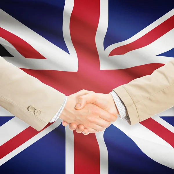 Businessmen handshake with flag on background - United Kingdom — Stock Photo, Image