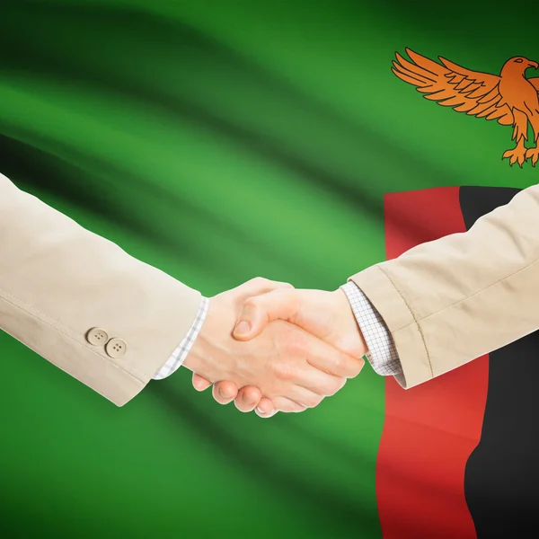 Apretón de manos de empresarios con bandera sobre fondo - Zambia —  Fotos de Stock