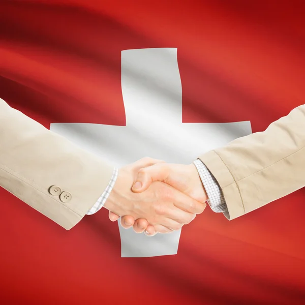 Businessmen handshake with flag on background - Switzerland — Stock Photo, Image