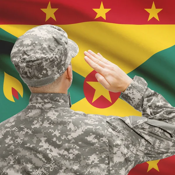 Солдат в шляпе, стоящие перед национальным флагом серии - Гренада — стоковое фото