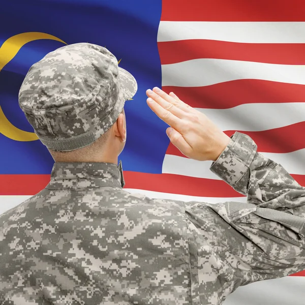 Soldier in hat facing national flag series - Malaysia — Stock Photo, Image