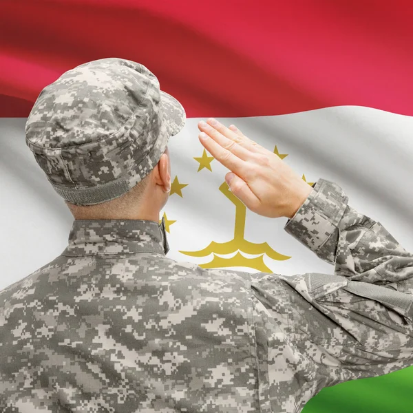 Soldat au chapeau face à la série des drapeaux nationaux - Tadjikistan — Photo