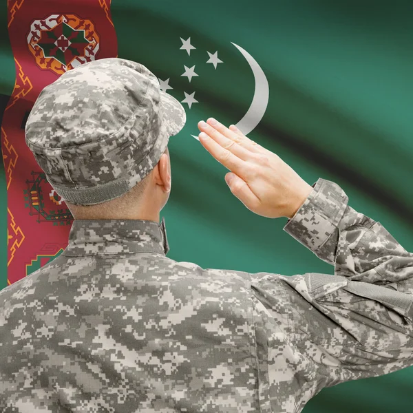Солдат в шляпе, стоящие перед национальным флагом серии - Туркменистан — стоковое фото
