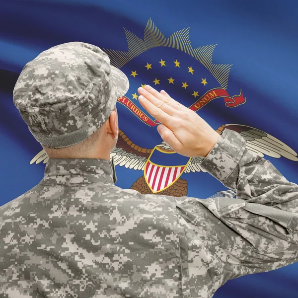 Soldier saluting to US state flag series - North Dakota — Stock Photo, Image