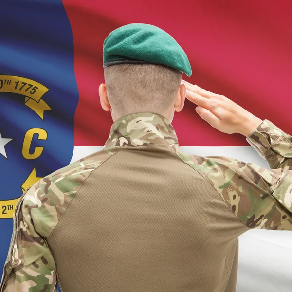 Soldier saluting to USA state flag conceptual series - North Car — Stockfoto