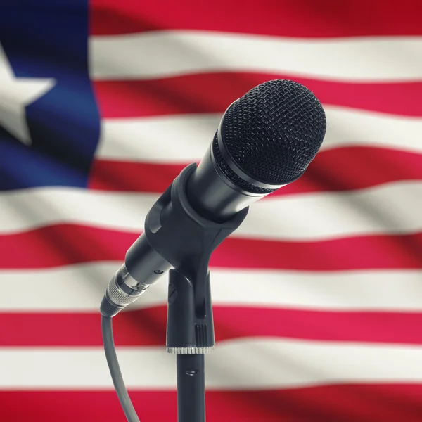 Microfono sul basamento con la bandiera nazionale su priorità bassa - Liberia — Foto Stock