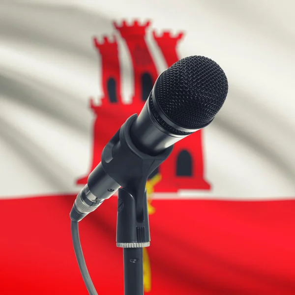 Micrófono en pedestal con bandera nacional de fondo - Gibraltar — Foto de Stock