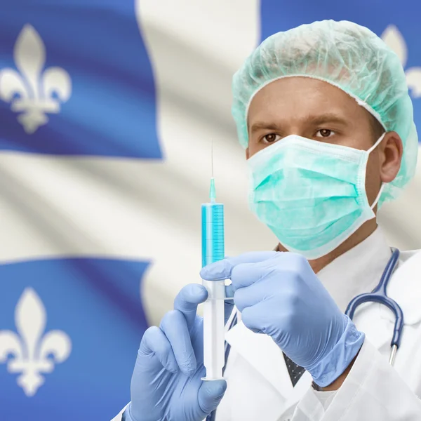 Médico con jeringa en las manos y de la serie bandera de provincia de Canadá - Quebec — Foto de Stock