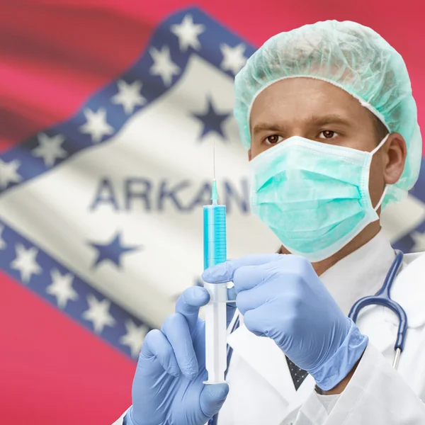 Médecin avec une seringue dans les mains et les États américains drapeaux series - Arkansas — Photo